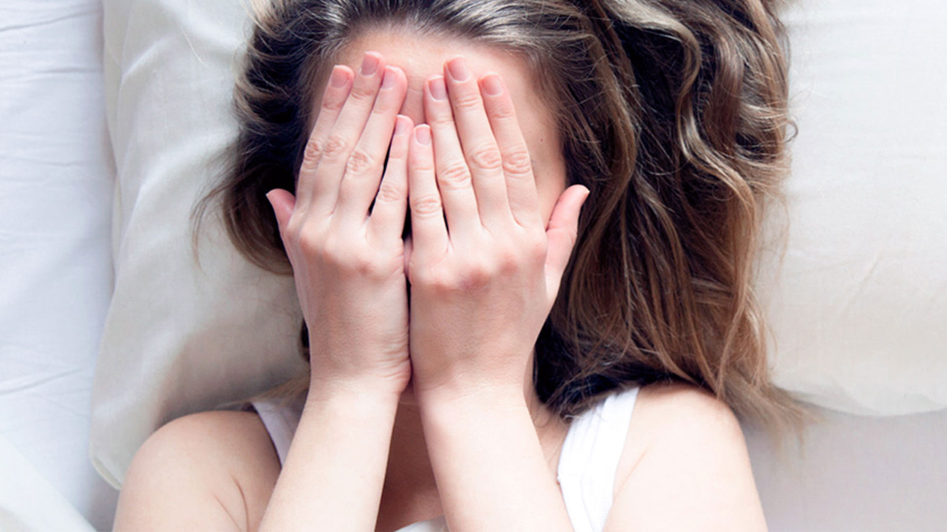 Femme cachant son visage avec ses mains