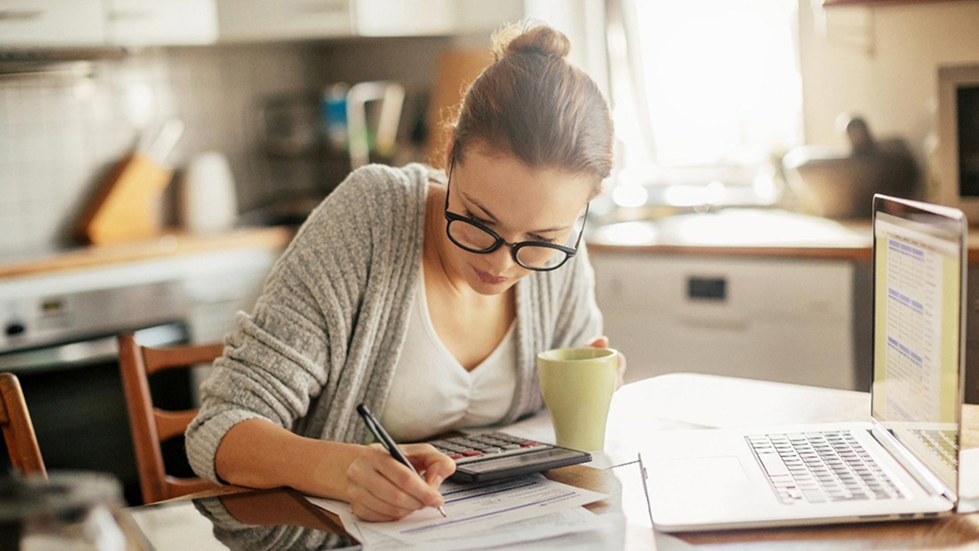 Femme à lunette noire travaillant devant son ordinateur