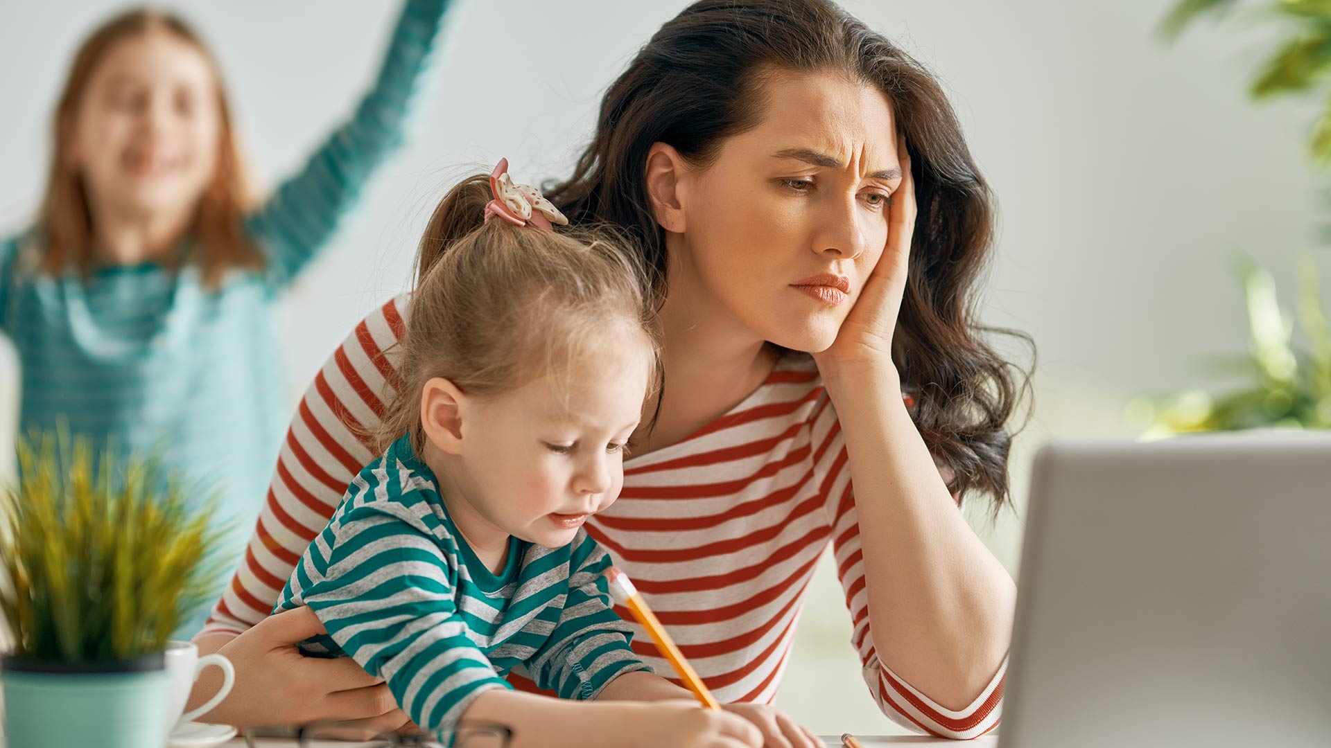 Femmes fatiguée devant l'ordinateur avec ses enfants